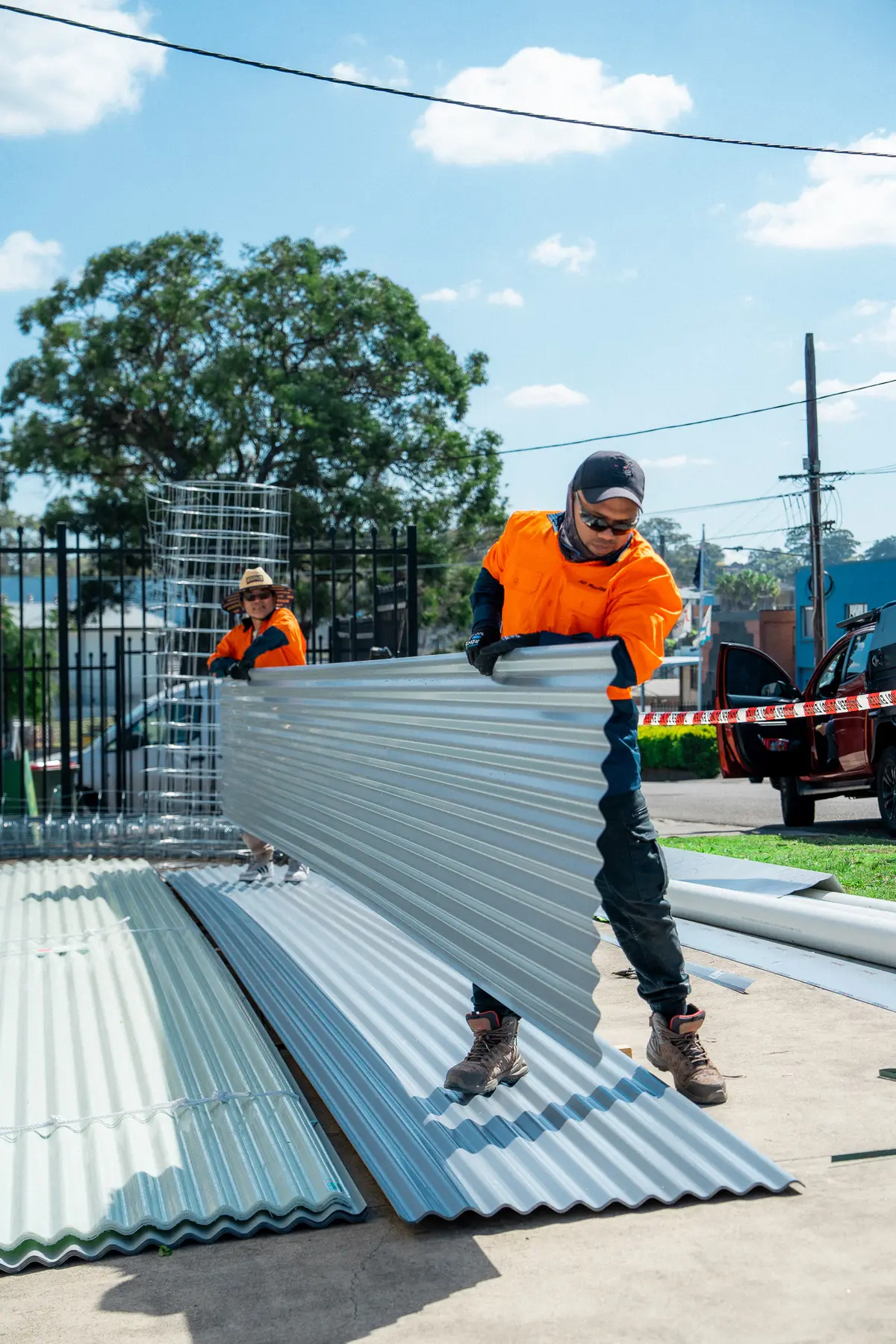 AD Roofing roofer carrying a new corrugated roof sheet