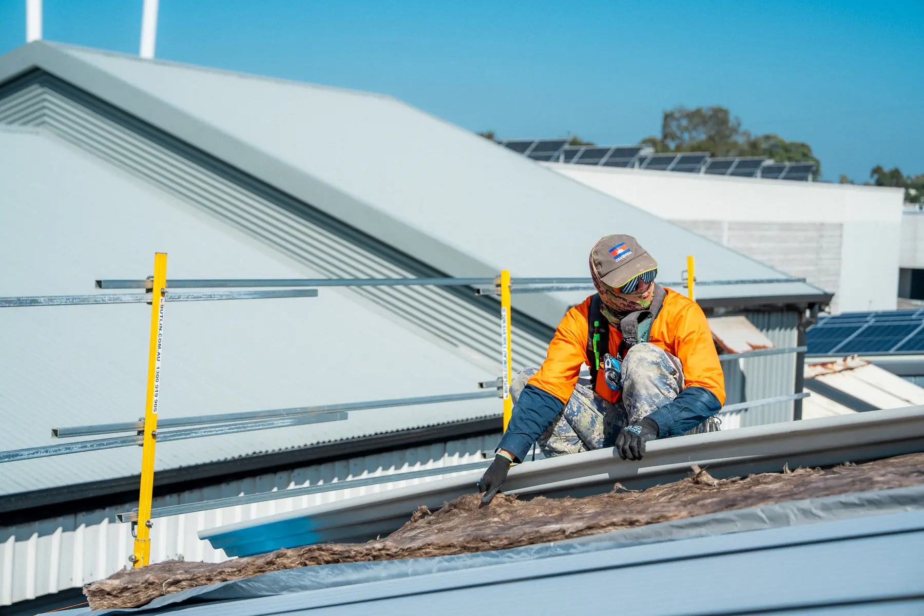 Roofer in a face mask stripping old roof material