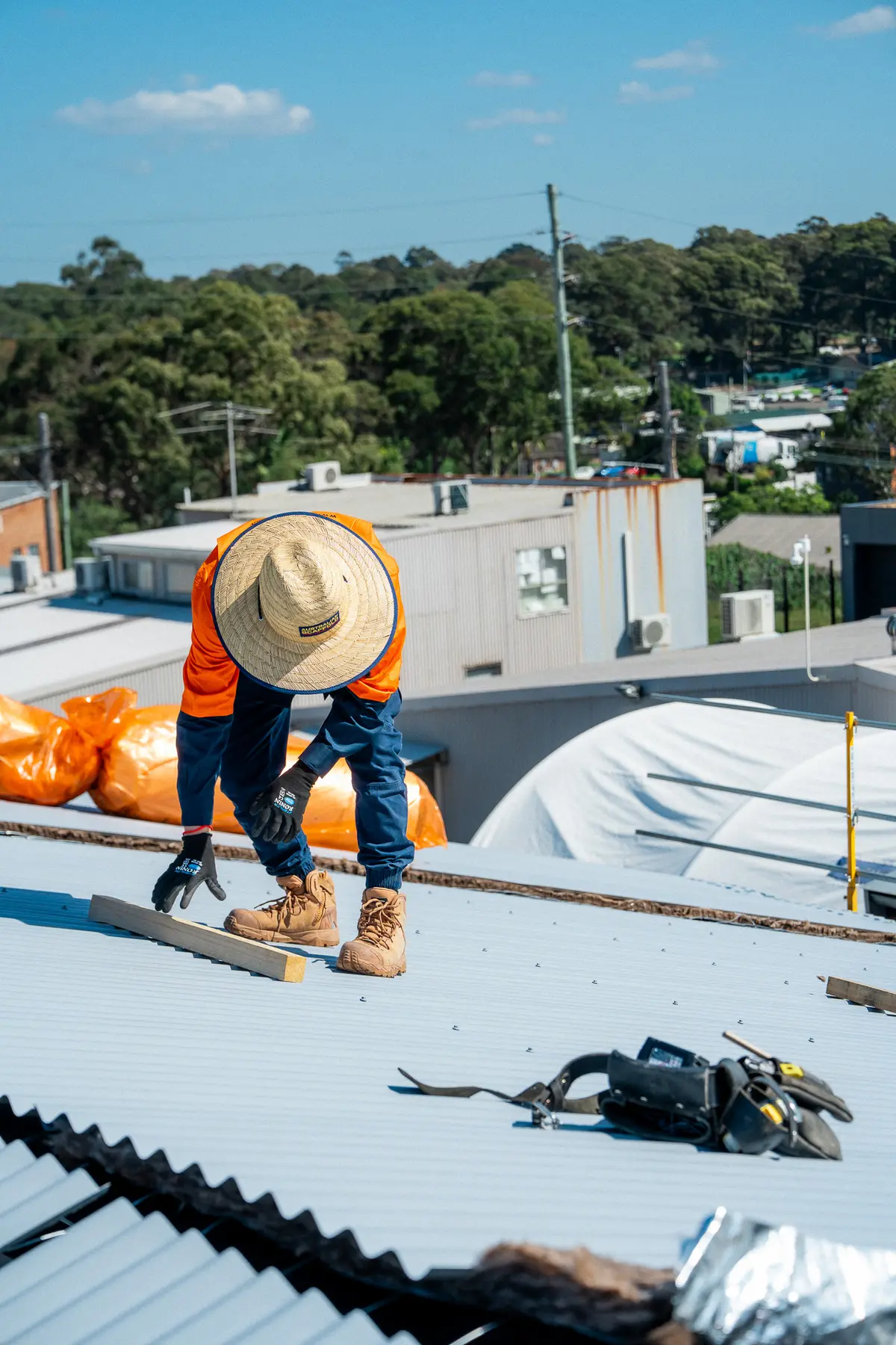 Roofer fixing new sheets on an industrial roof