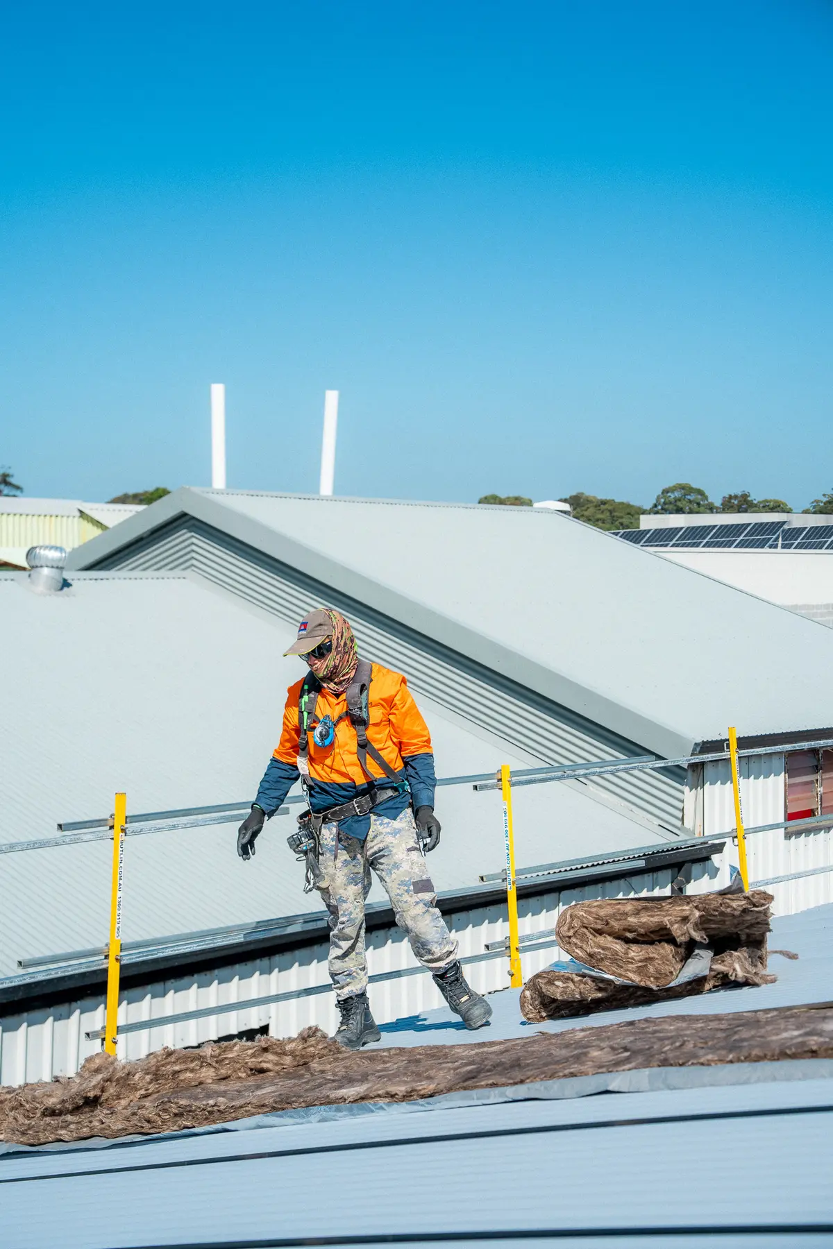 Roofer walking across the new roof with stripped insulation