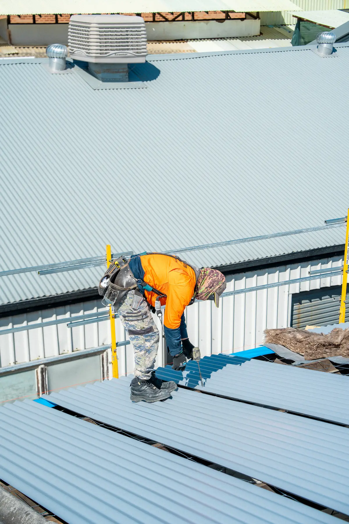 Roofer working along the edge of an industrial roof