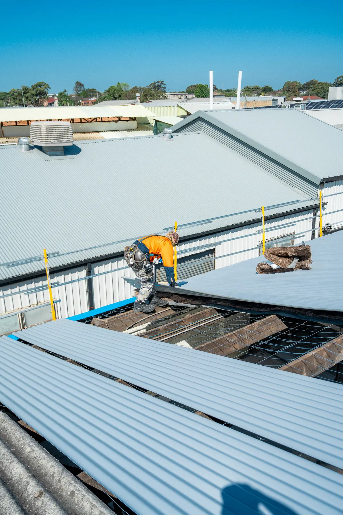 Roofer beside an open roof section with the purlins exposed