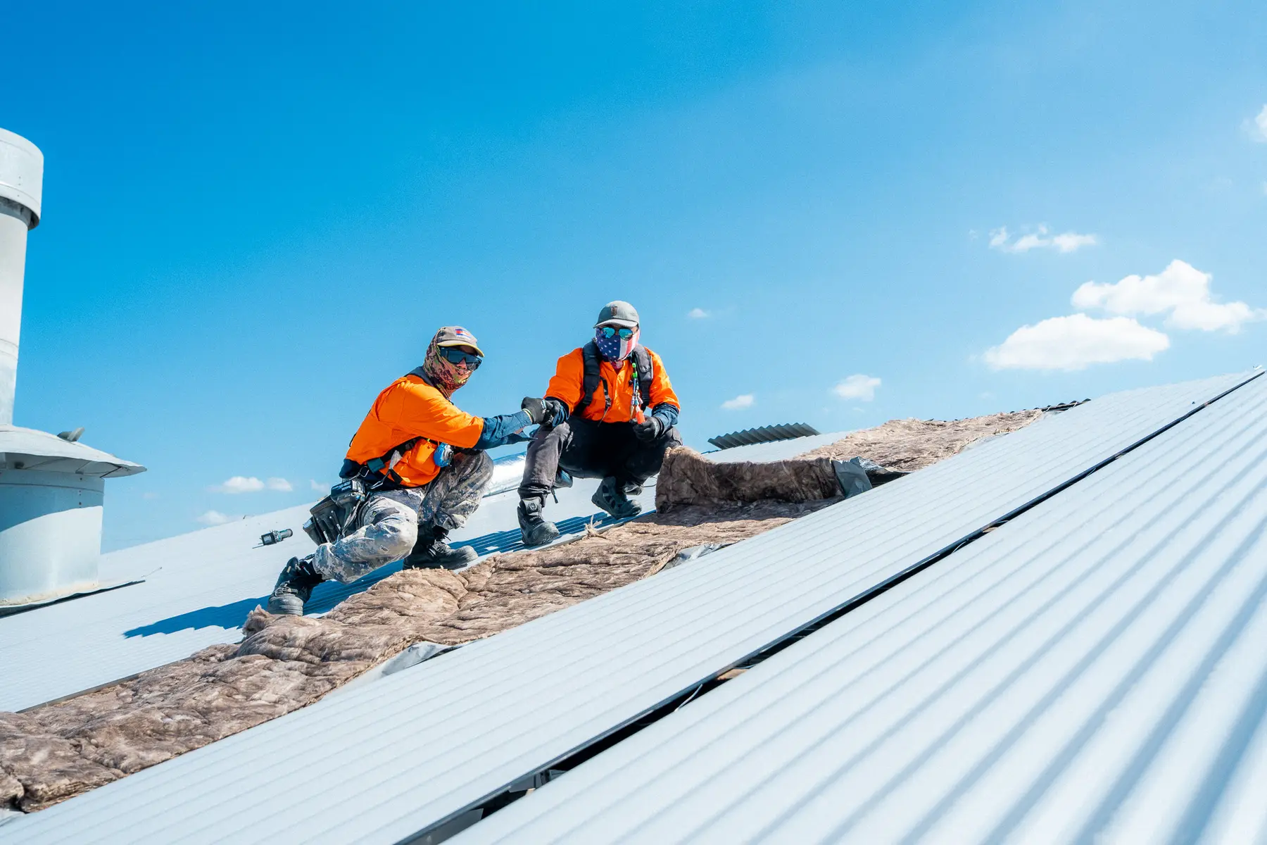 Two AD Roofing roofers on a newly laid metal roof