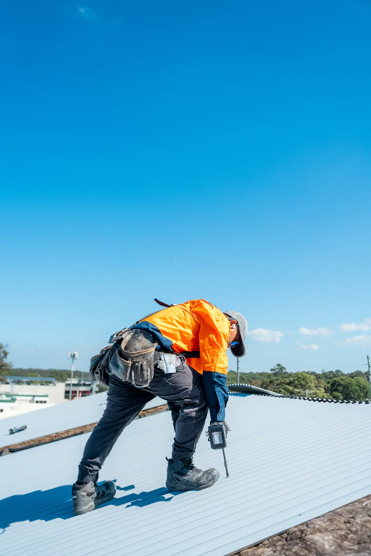 Roofer working across freshly laid metal roof sheets