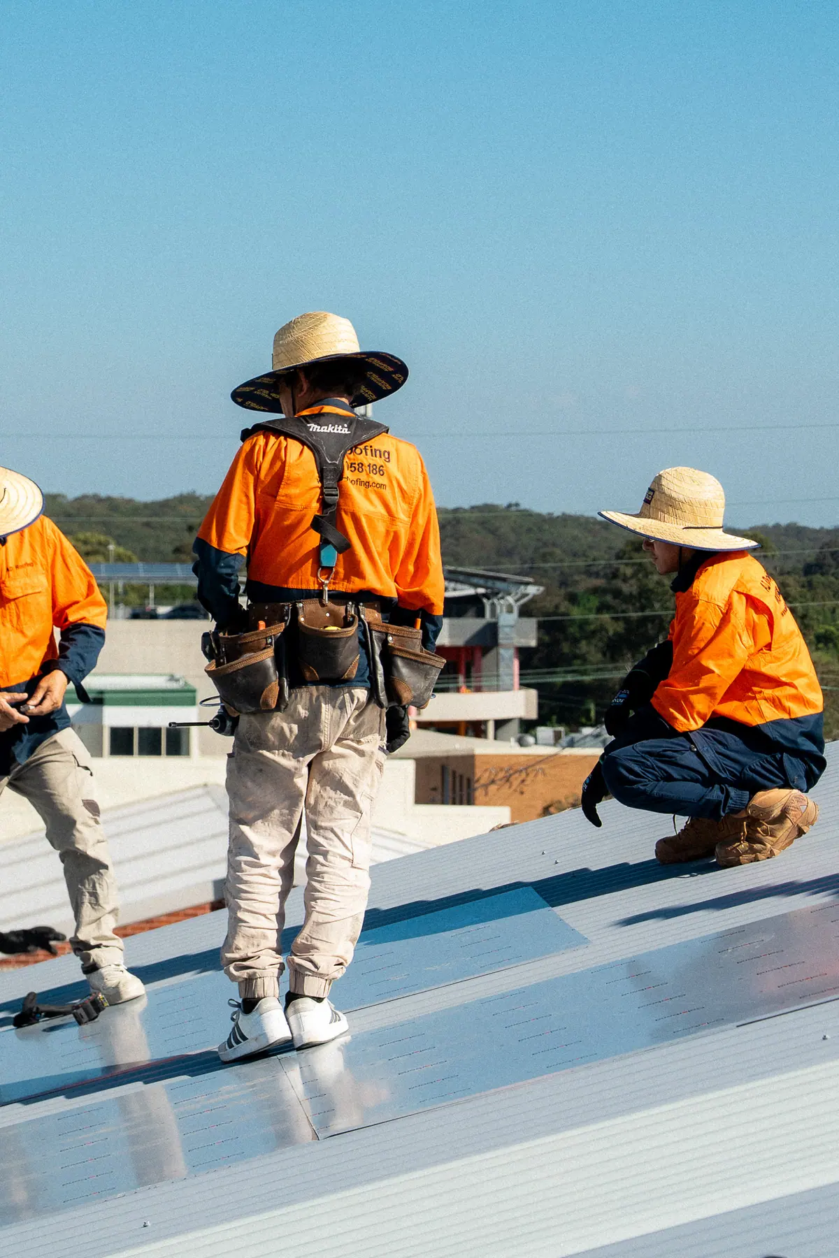 Roofers in wide-brim hats working across the new roof