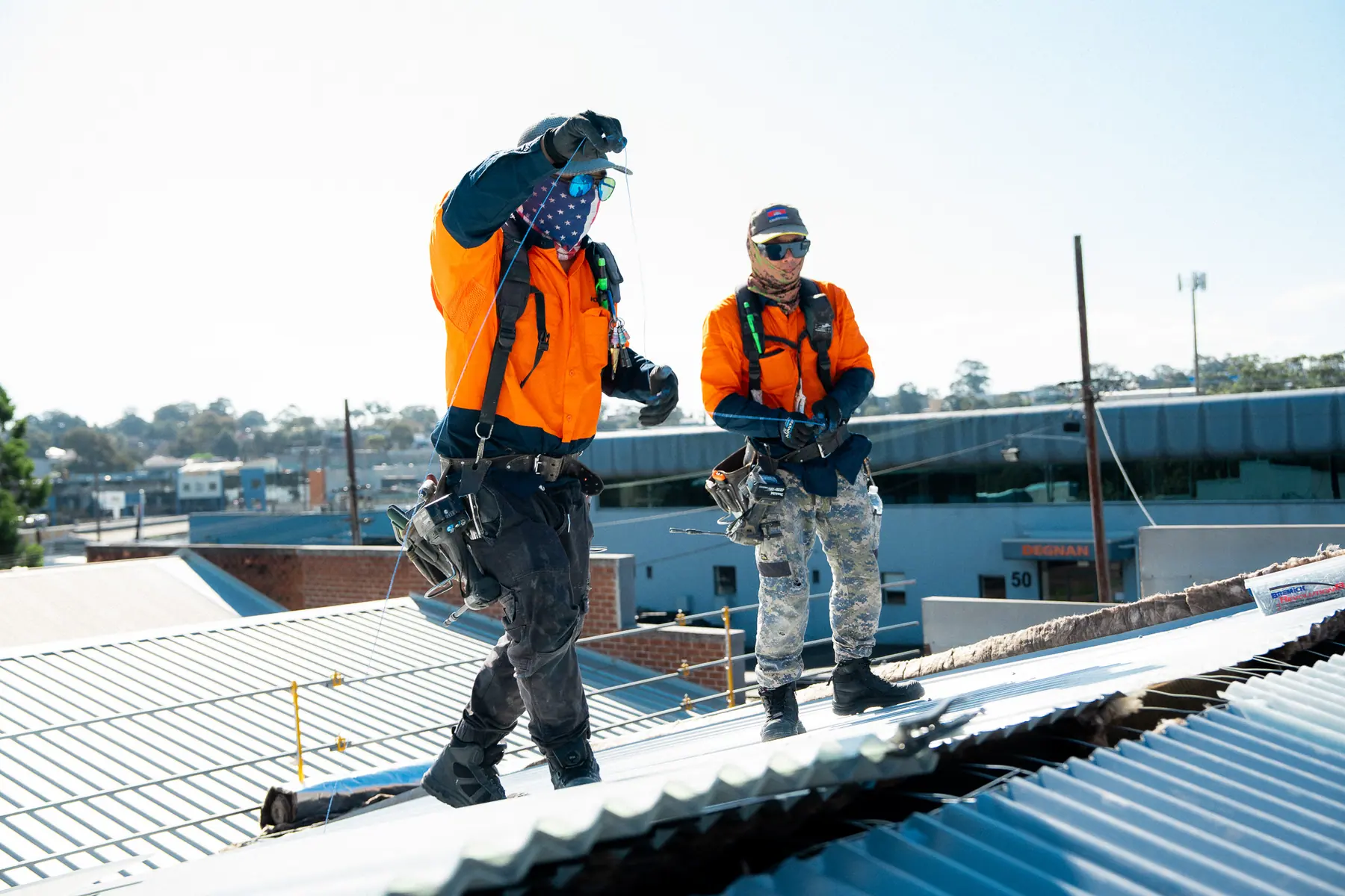 Two AD Roofing roofers walking across the new roof sheets