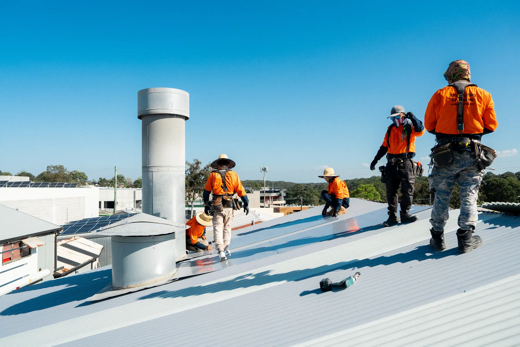 Crew working across the new roof with a ventilator in the foreground