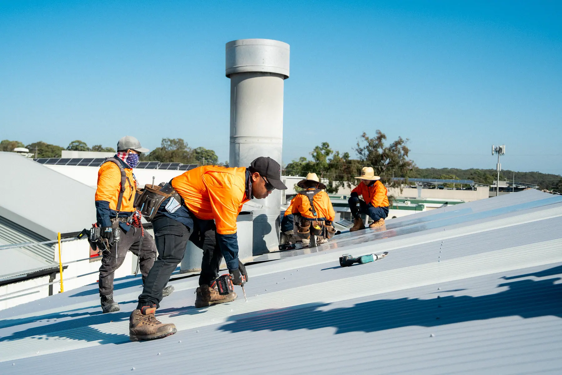 Crew fixing down a run of new metal roof sheets