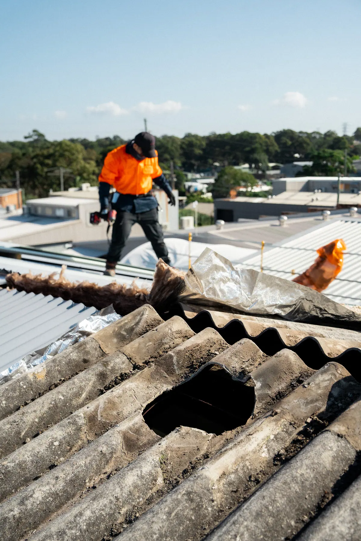 Old fibre-cement roof sheets with a broken section, ready for removal